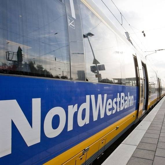 Der Zug des Unternehmens Nordwestbahn steht an einem Bahnsteig.
