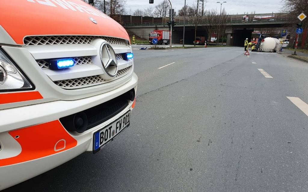 Im Vordergrund ist ein Feuerwehrfahrzeug zu sehen, im Hintergrund liegt der Gastank auf der Straße