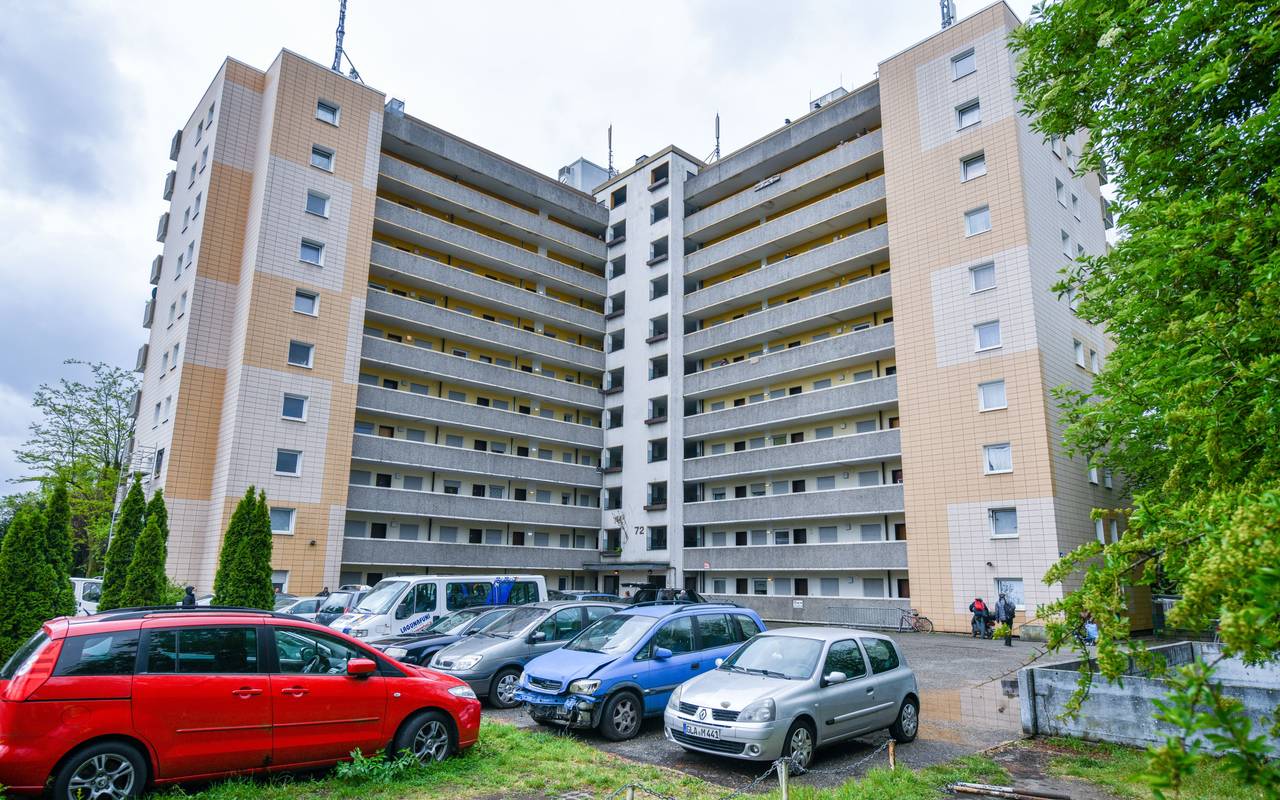 Ein Hochhaus in Gladbeck, davor stehen teils defekte Autos.