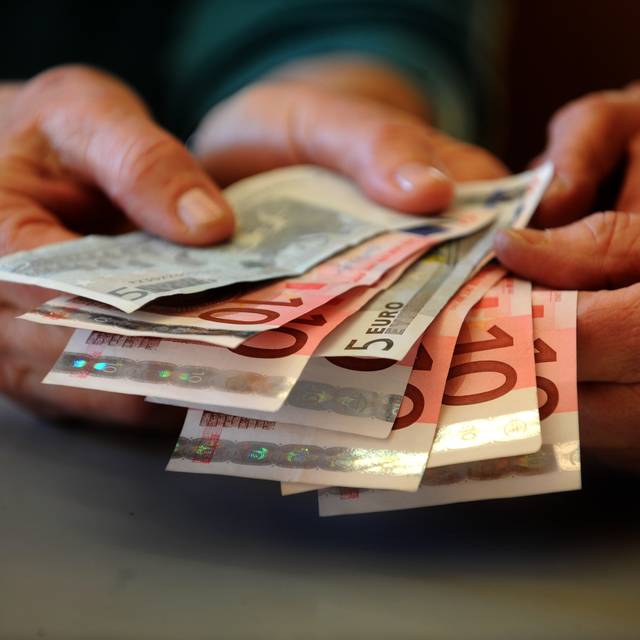 Hände halten einige Geldscheine