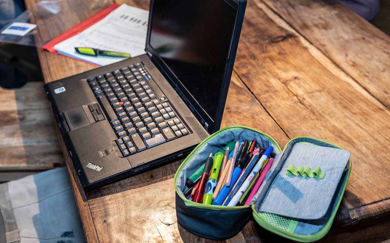 Laptop, Arbeitsblatt und Etui liegen auf einem Tisch