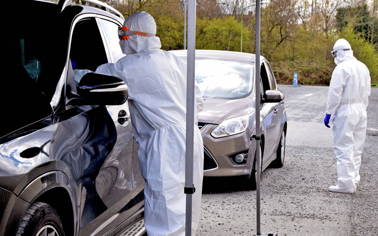 Ein Mitarbeiter der Drive-In-Teststelle in Bottrop nimmt einen Abstrich