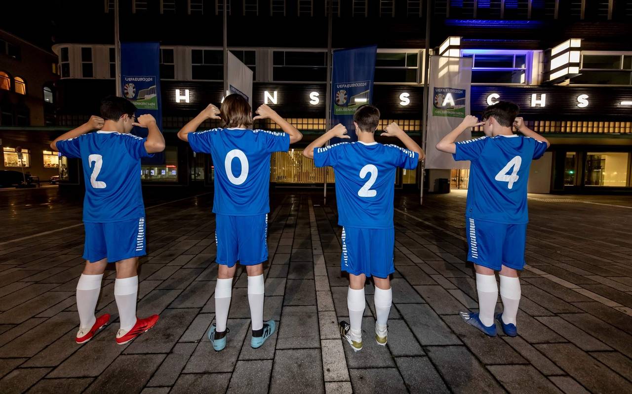 Kinder mit blauen Trikots und der Zahl 2024 stehen vor dem Hans-Sachs-Haus
