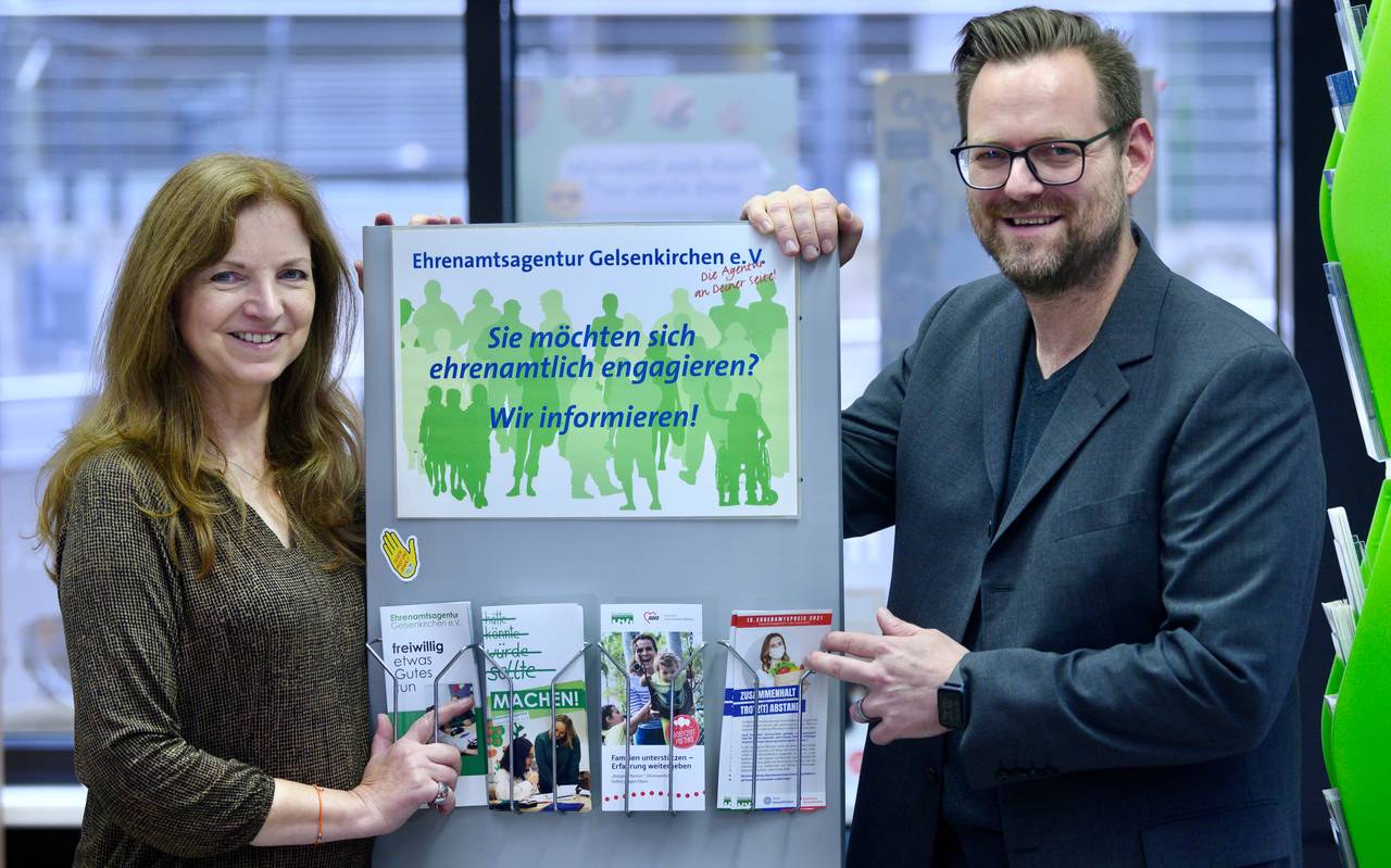 Mitarbeiter vor einem Schild der Ehrenamtsagentur Gelsenkirchen