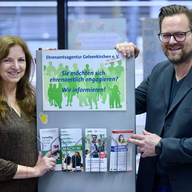 Mitarbeiter vor einem Schild der Ehrenamtsagentur Gelsenkirchen