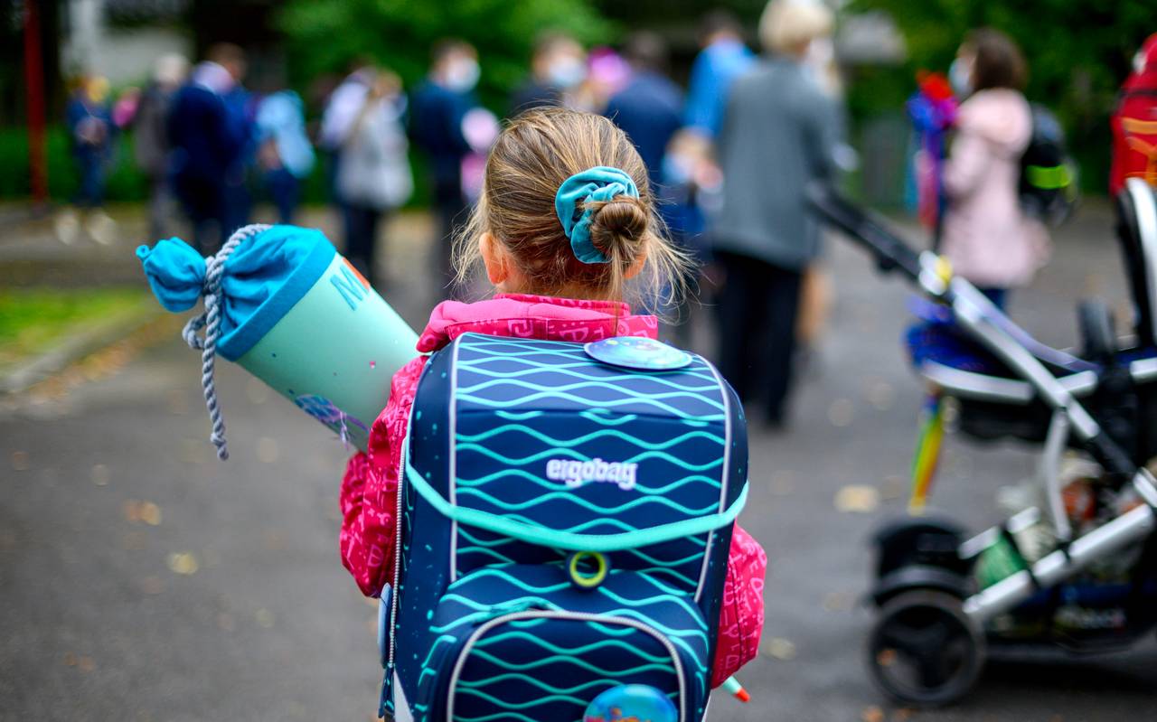 Eine Schulanfängerin mit Tornister und Schultüte