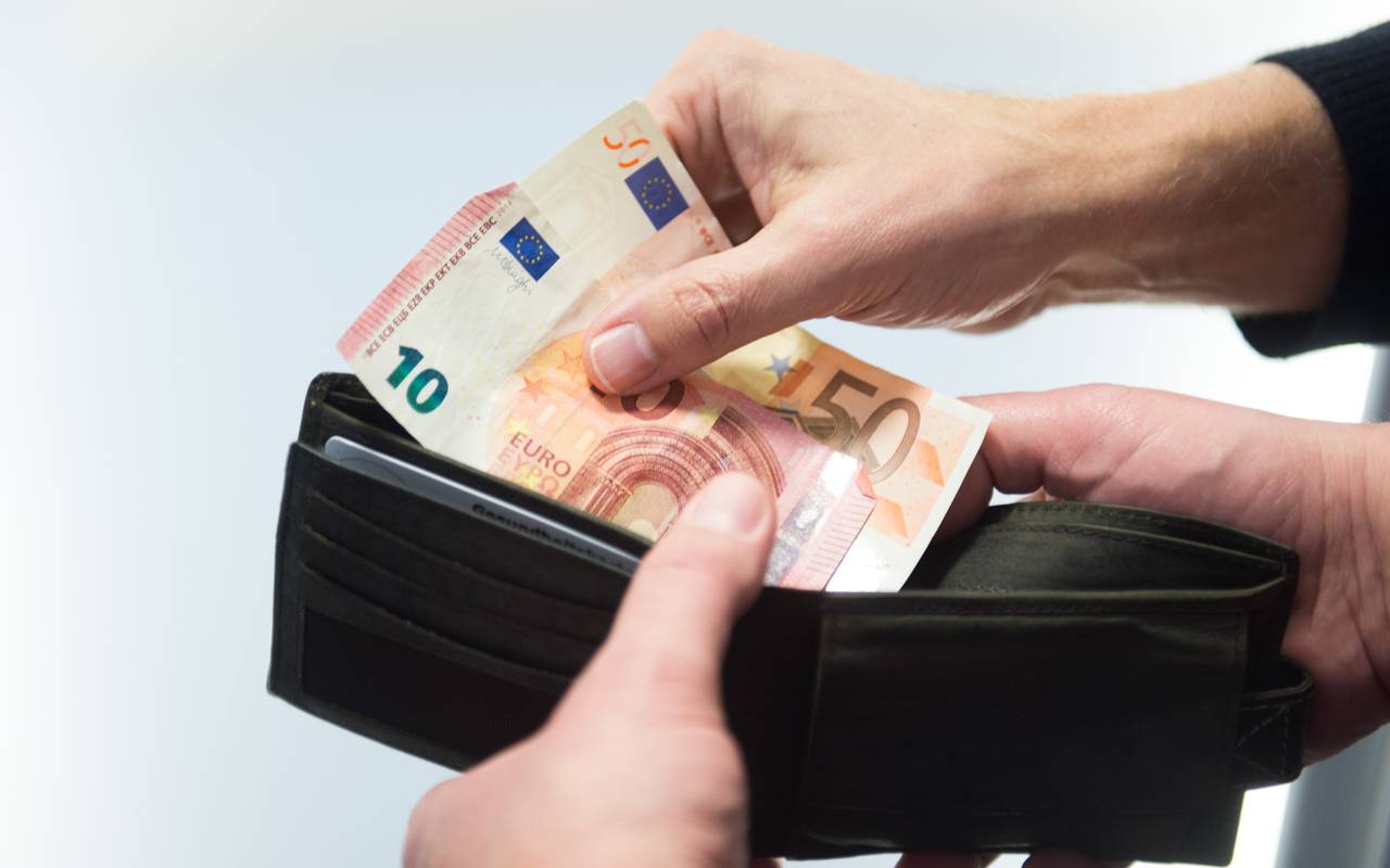 Ein Geldschein wird aus einem Portemonnaie gezogen