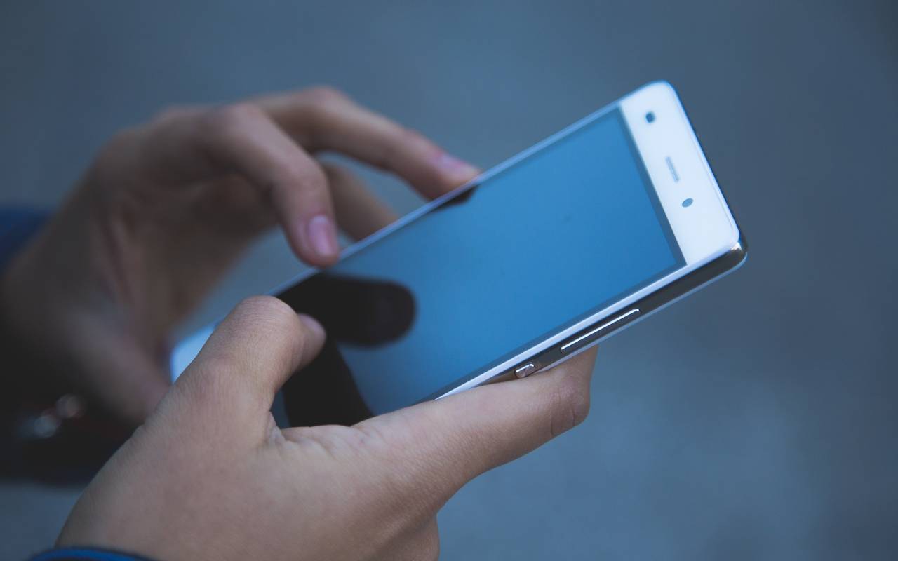 Mensch mit Handy in der Hand
