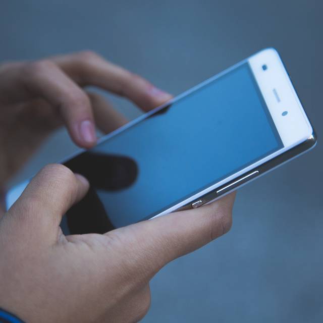 Mensch mit Handy in der Hand