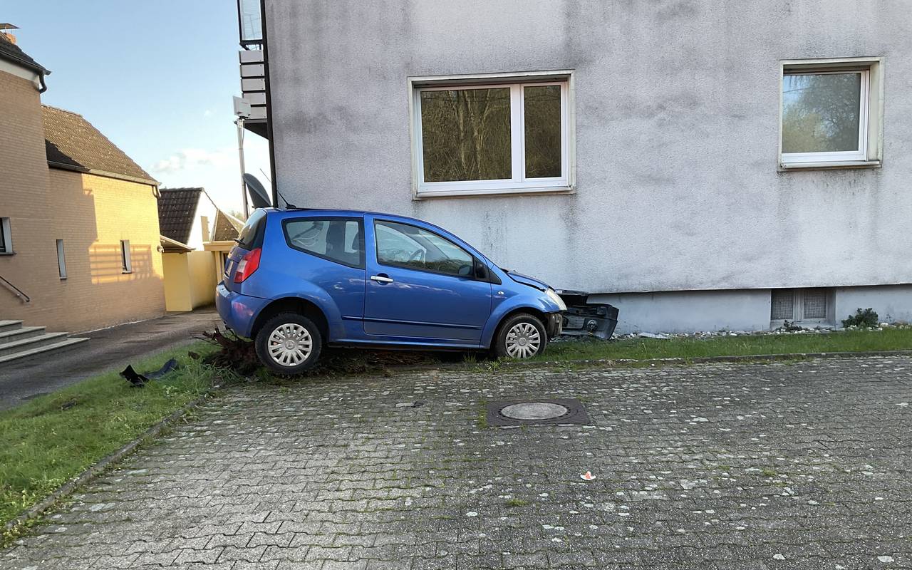 Ein blaues Auto an einer Hausfassade