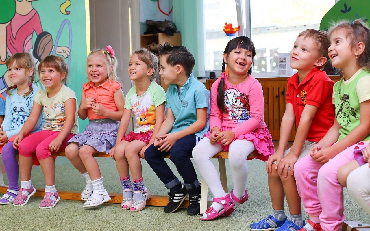 Eine Gruppe Kleinkinder sitzen in einem Kindergarten-Kreis