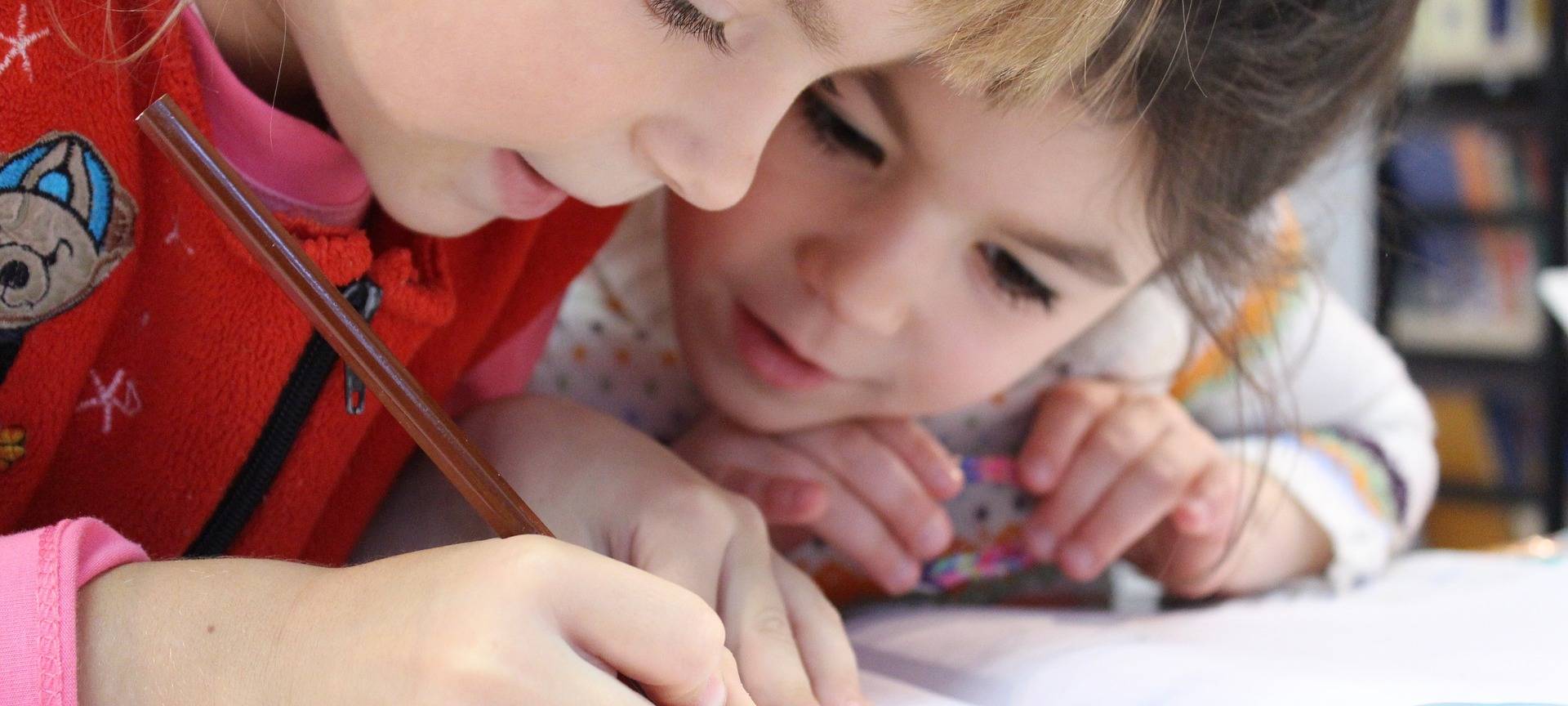 Grundschulkinder schreiben in einem Heft