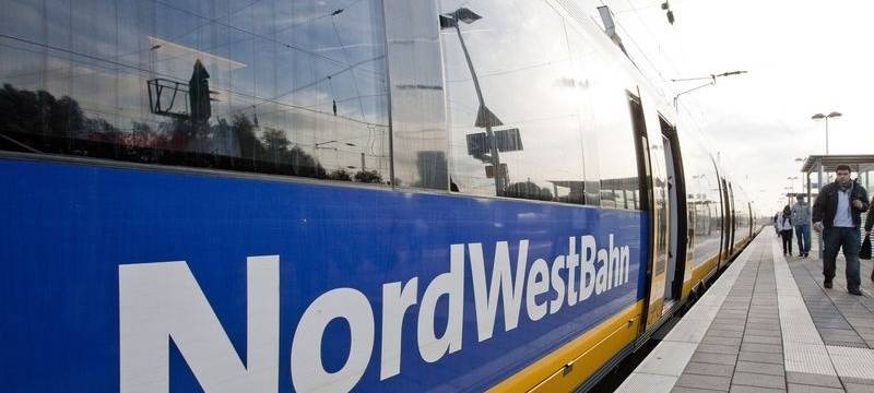 Der Zug des Unternehmens Nordwestbahn steht an einem Bahnsteig.