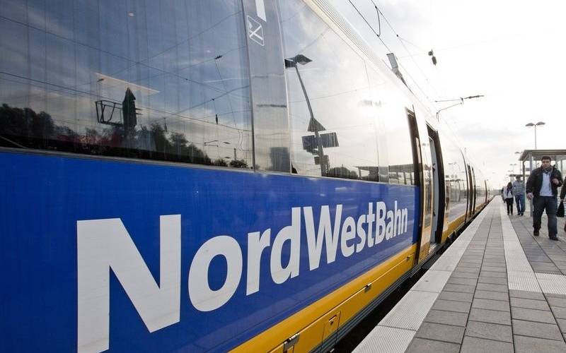 Der Zug des Unternehmens Nordwestbahn steht an einem Bahnsteig.