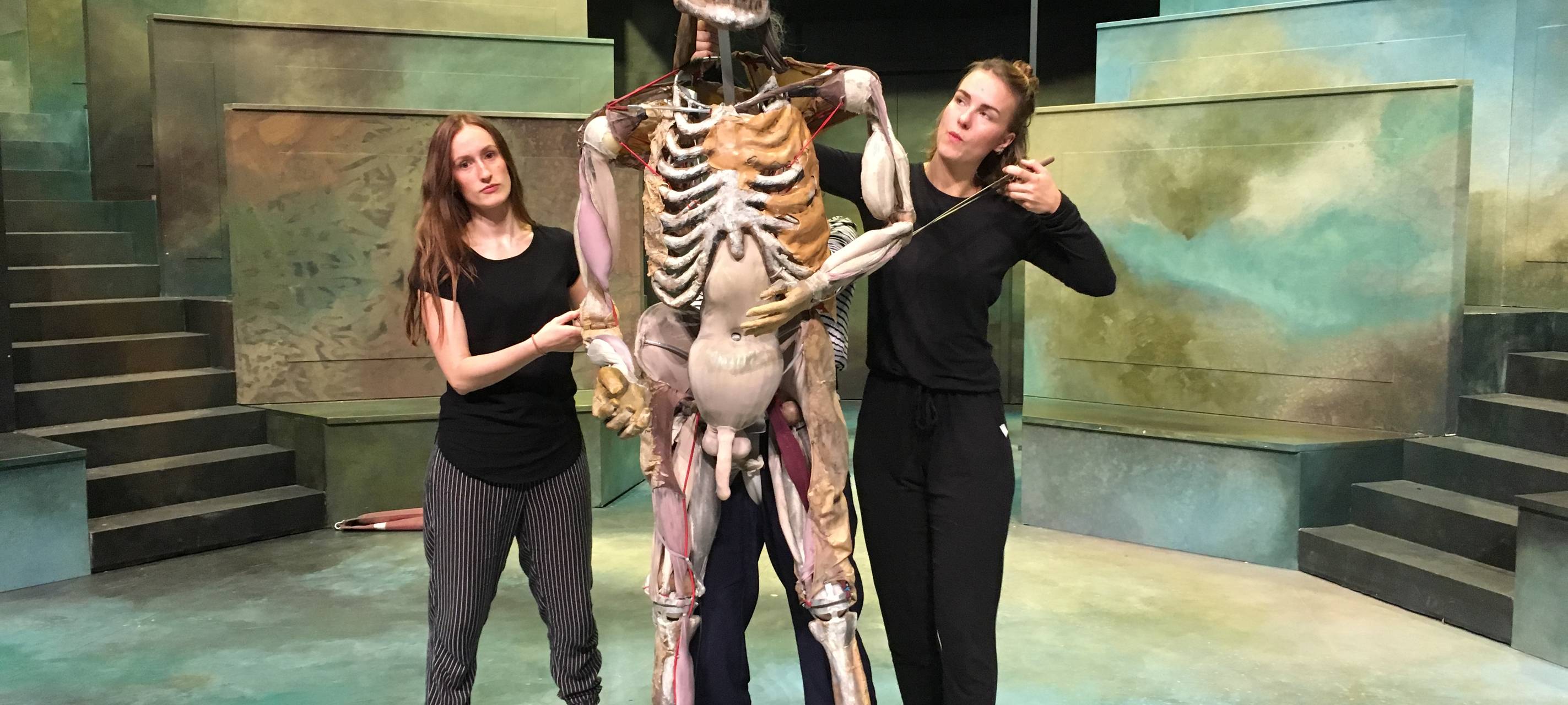 Eine lebensgroße Frankenstein-Puppe und drei Puppenspielerinnen.