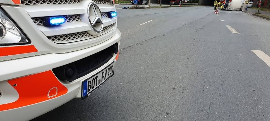 Im Vordergrund ist ein Feuerwehrfahrzeug zu sehen, im Hintergrund liegt der Gastank auf der Straße