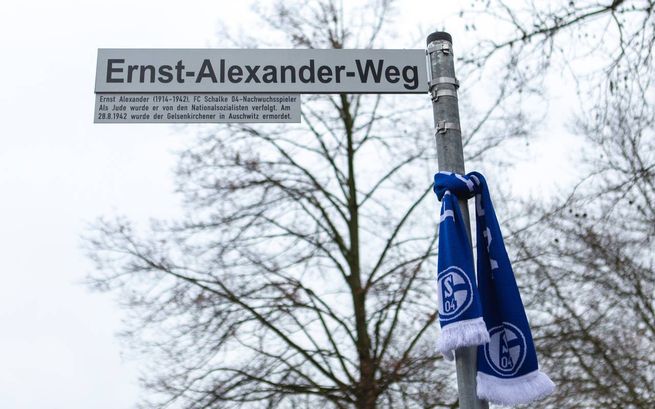 Das Straßenschild Ernst-Alexander-Weg, an dem Schildermast hängt ein Schalkeschal
