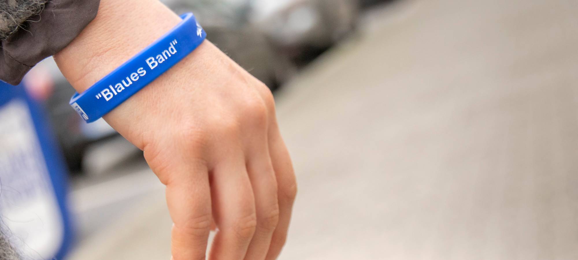 Blaues Gummiband mit Aufschrift "Blaues Band" an Handgelenk