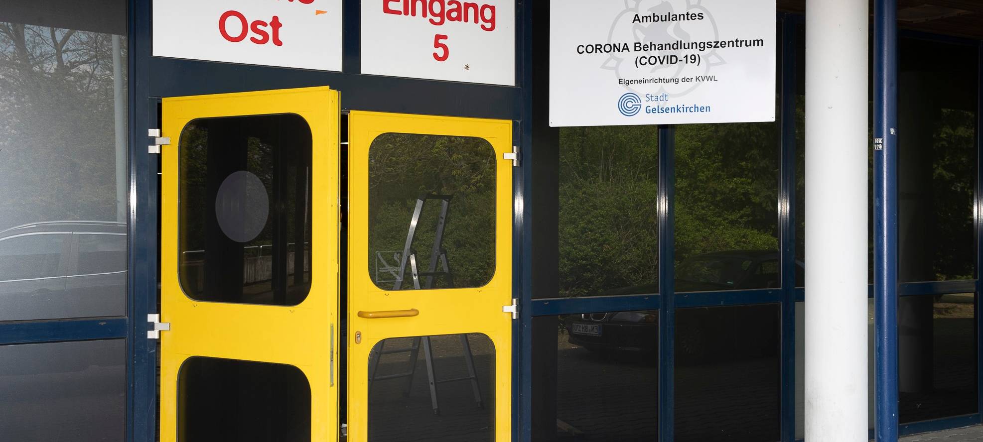 Gelbe Eingangstüren am Sportparadies, darüber ein Hinweisschild auf das Behandlungszentrum.