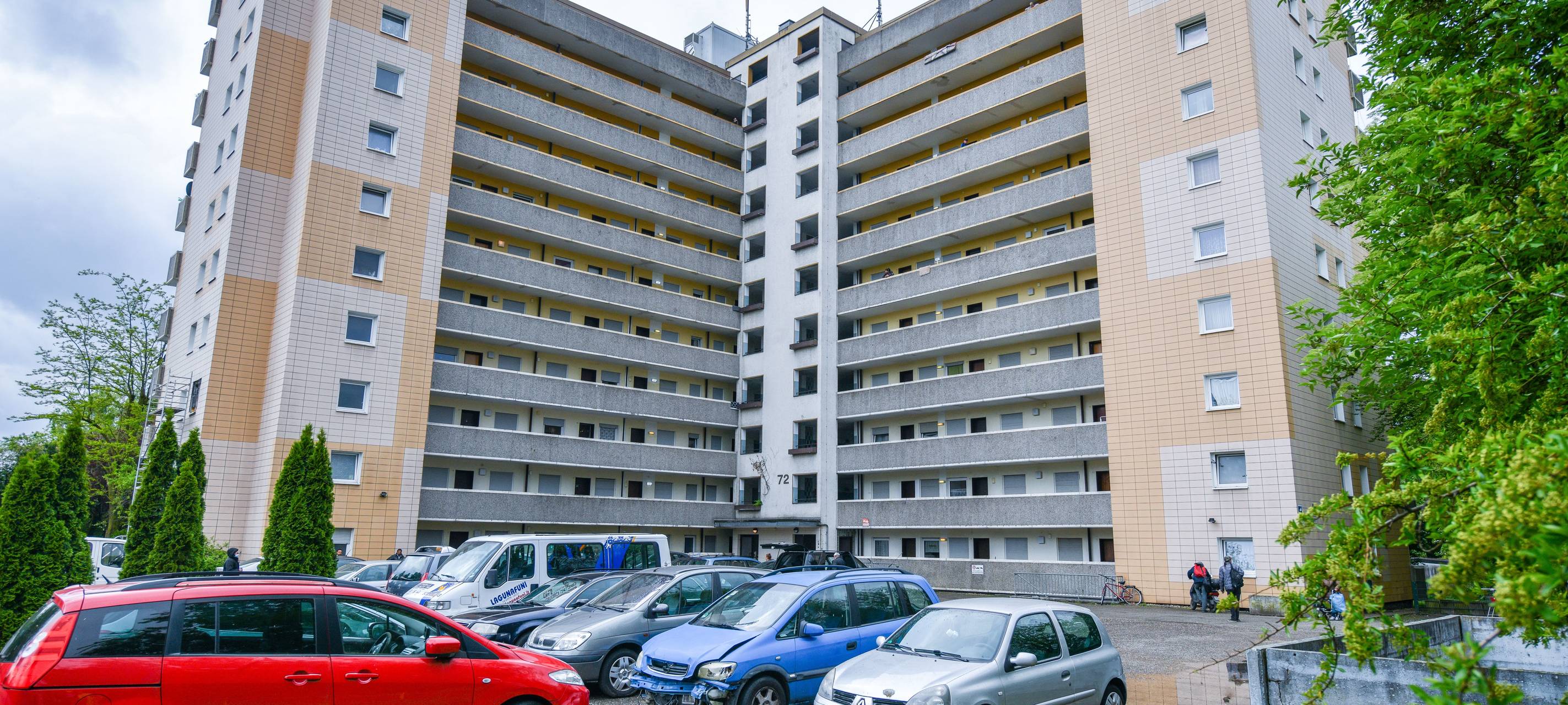 Ein Hochhaus in Gladbeck, davor stehen teils defekte Autos.