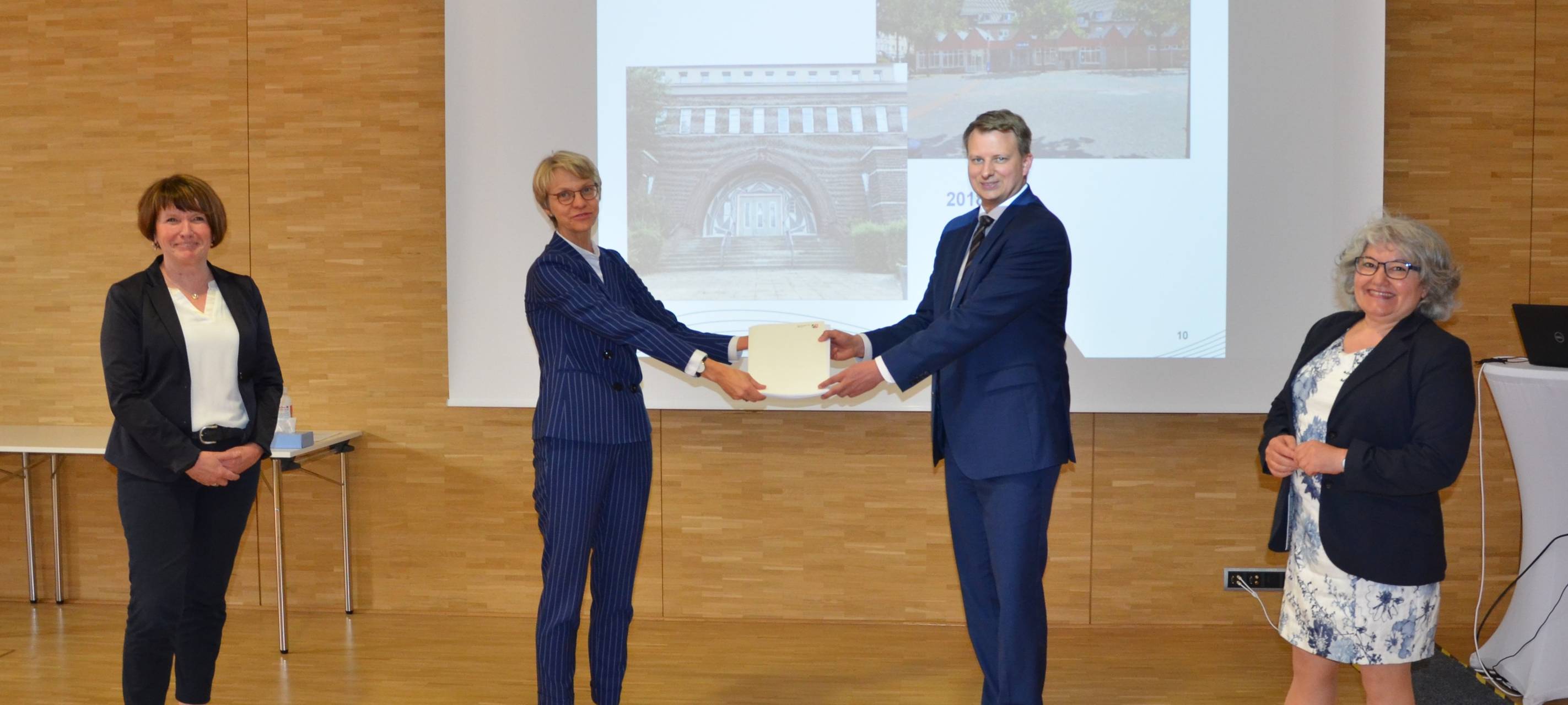 Regierungspräsidentin Dorothee Feller übergibt einen Förderbescheid an Gelsenkirchens Stadtbaurat Christoph Heidenreich
