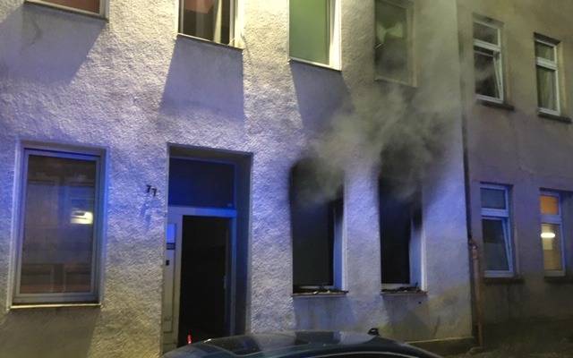 Dunkler Rauch dringt aus den Fenstern einer Erdgeschosswohnung