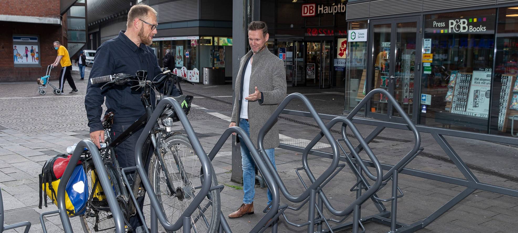 Zwei Männer stellen ein Fahrrad an den neuen Fahrradständern am Gelsenkirchener Hauptbahnhof ab