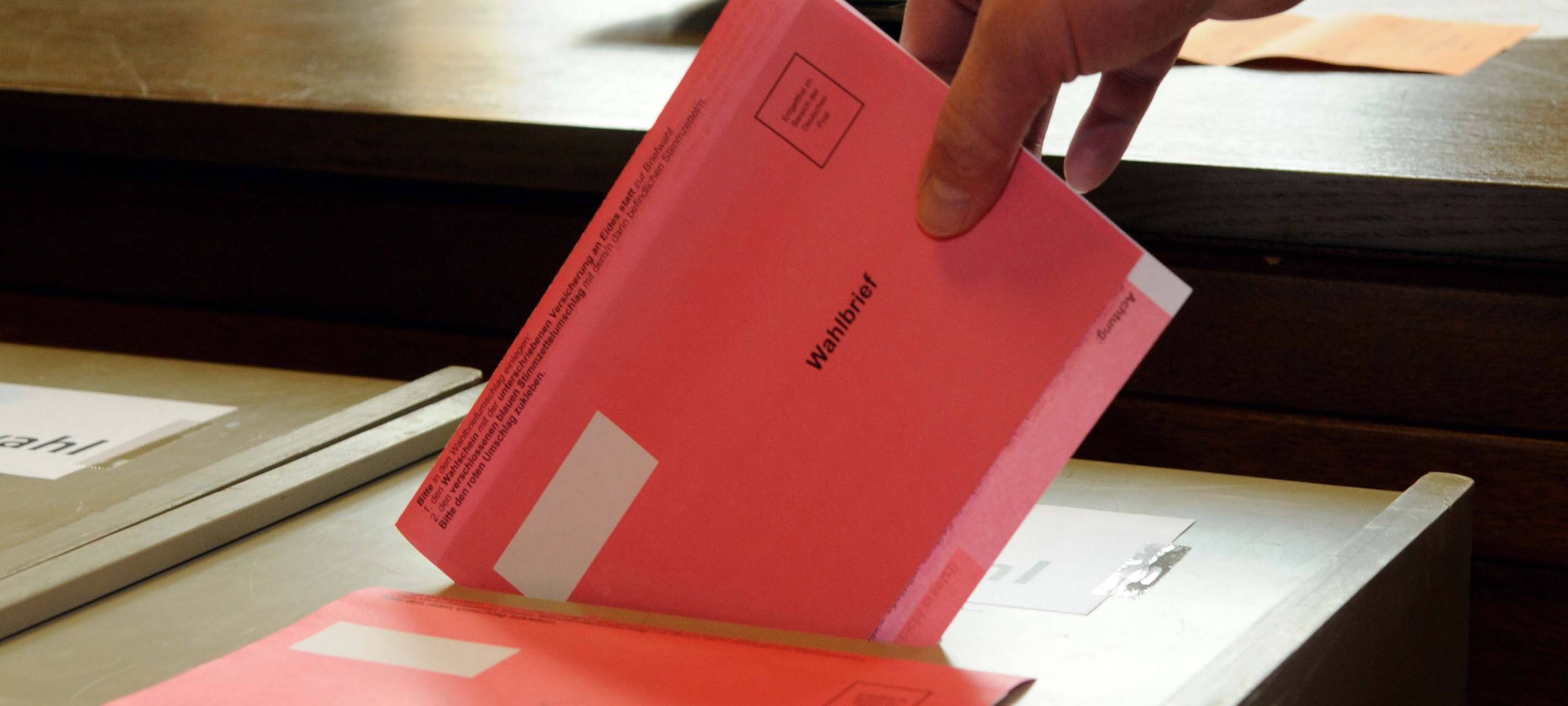 Ein Wahlbrief wird in die Wahlurne geworfen