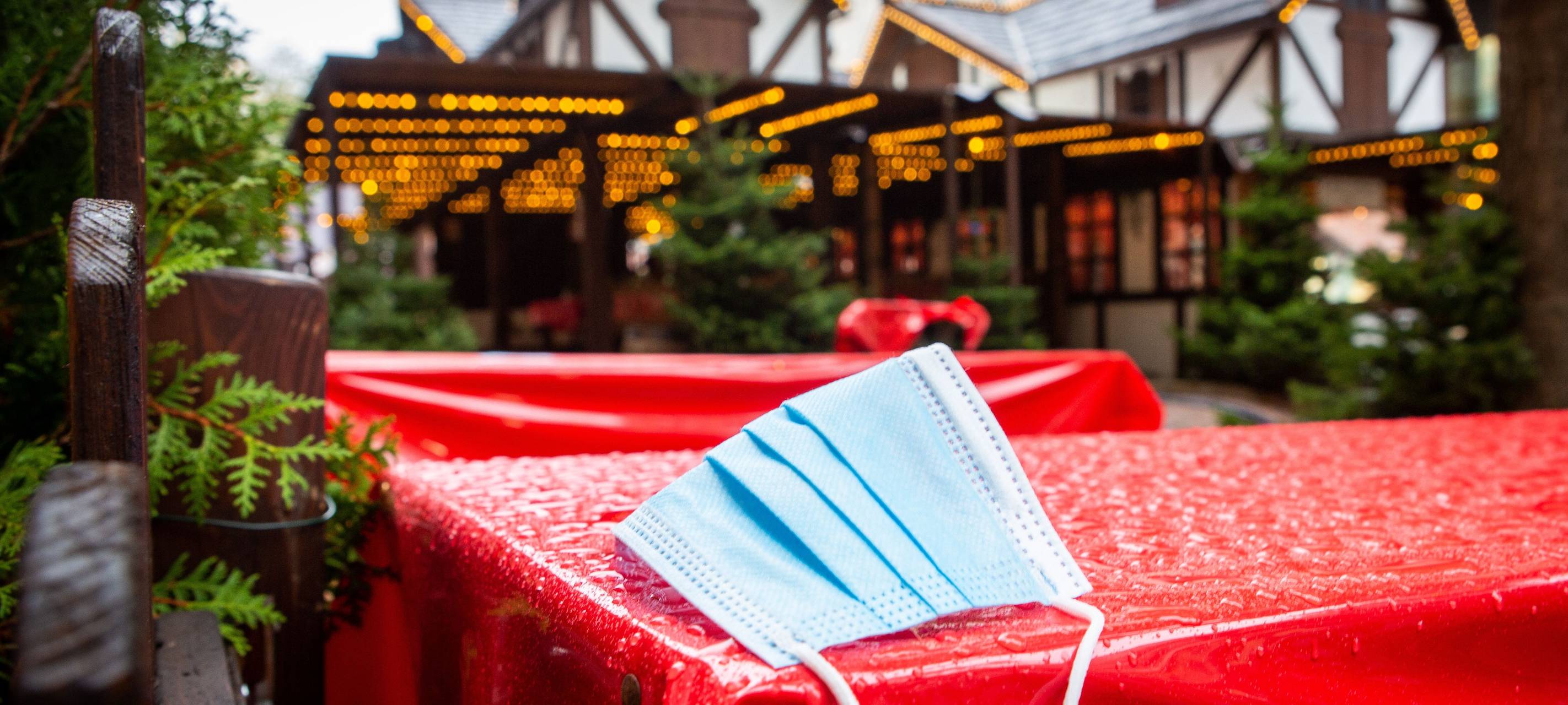 Corona-Maske vor einer Weihnachtsmarkt-Bude