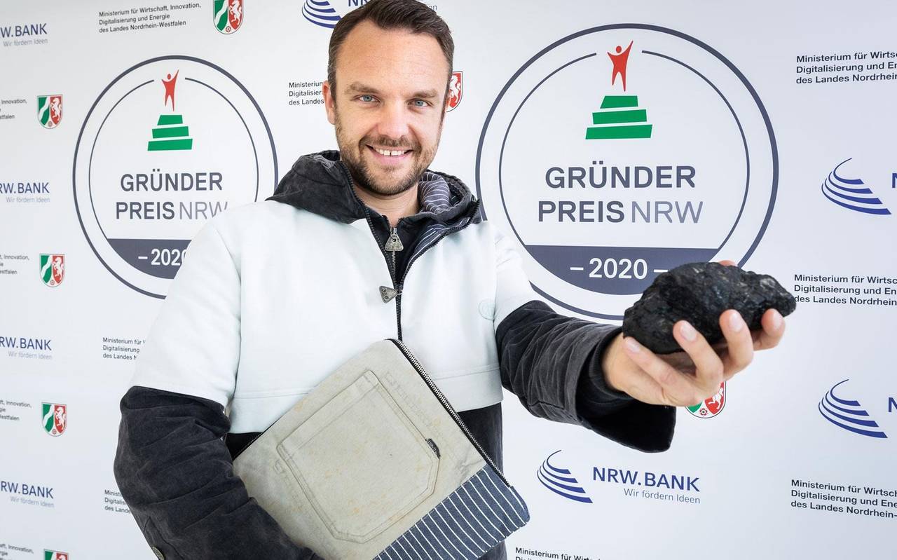 Grubenhelden-Chef Matthias Bohm vor einer Wand des Gründerpreises NRW