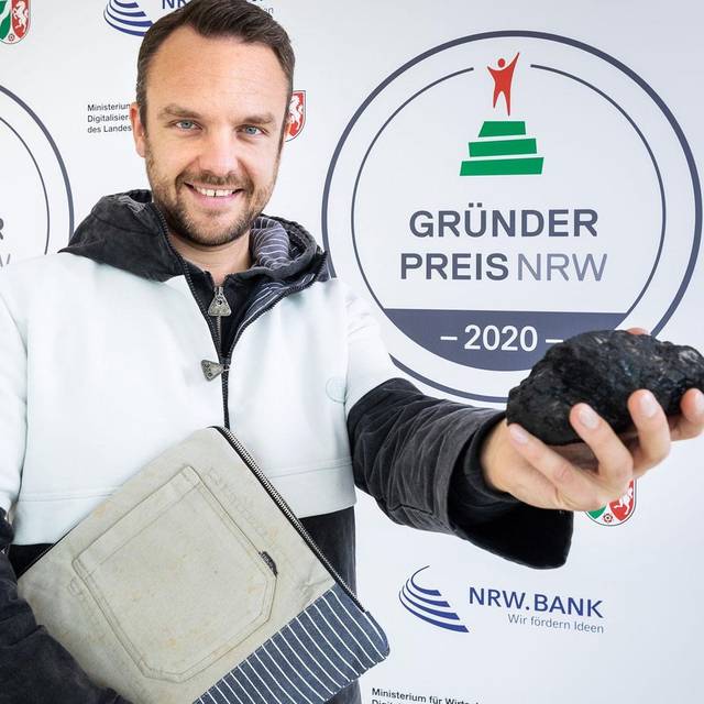 Grubenhelden-Chef Matthias Bohm vor einer Wand des Gründerpreises NRW