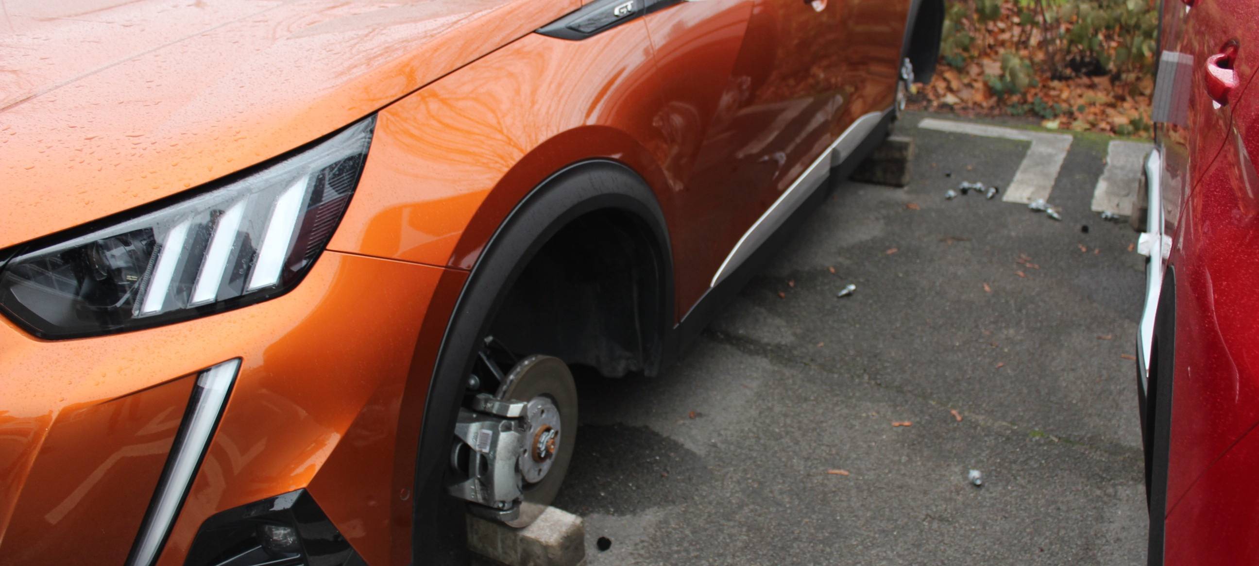 Ein Auto ist aufgebockt auf Steinen. Die Reifen fehlen.