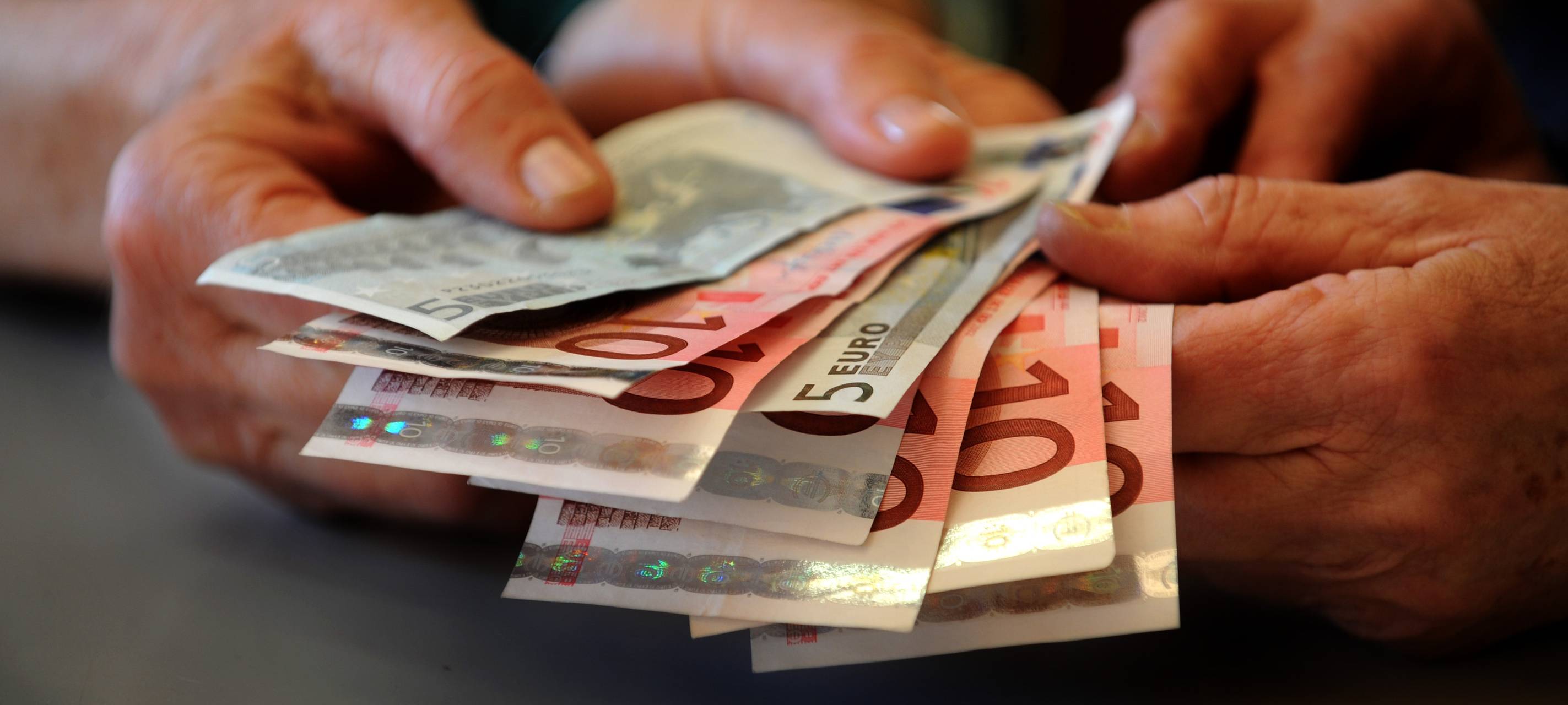 Hände halten einige Geldscheine