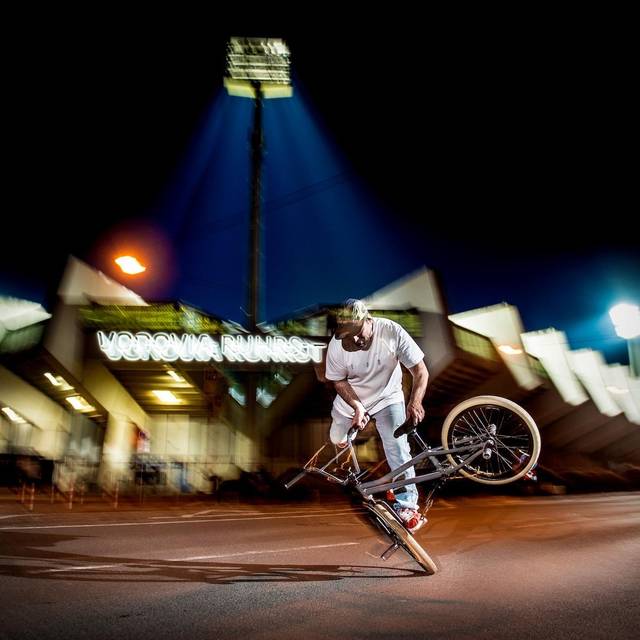 Ein BMX-Fahrer vor einem Stadion