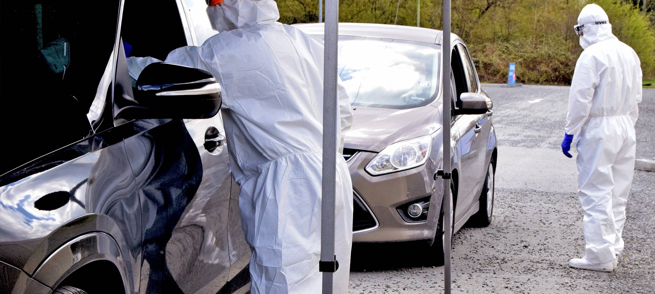 Ein Mitarbeiter der Drive-In-Teststelle in Bottrop nimmt einen Abstrich