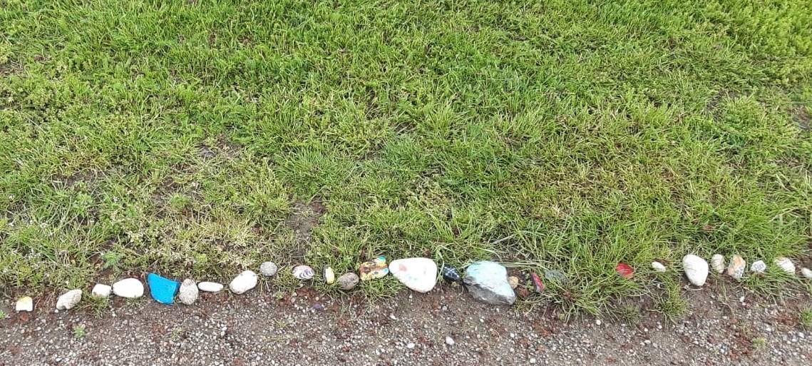 Bunt bemalte Steine liegen in einer Reihe nebeneinander