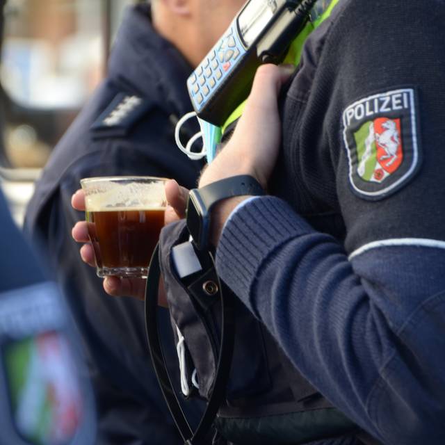 Ein Polizist mit Kaffeebecher