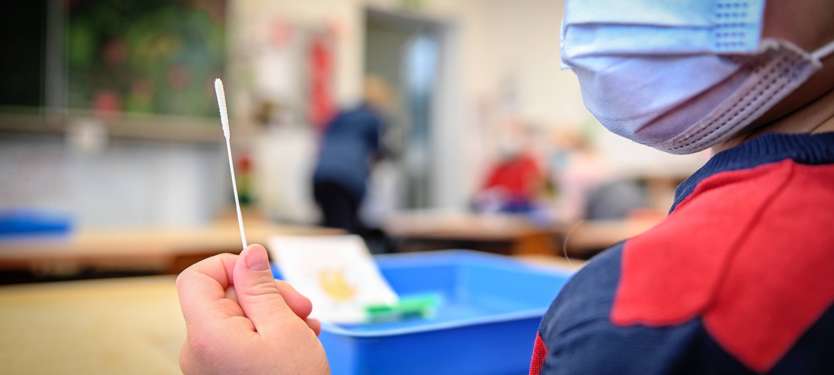 Schulkind mit Maske und Corona-Test