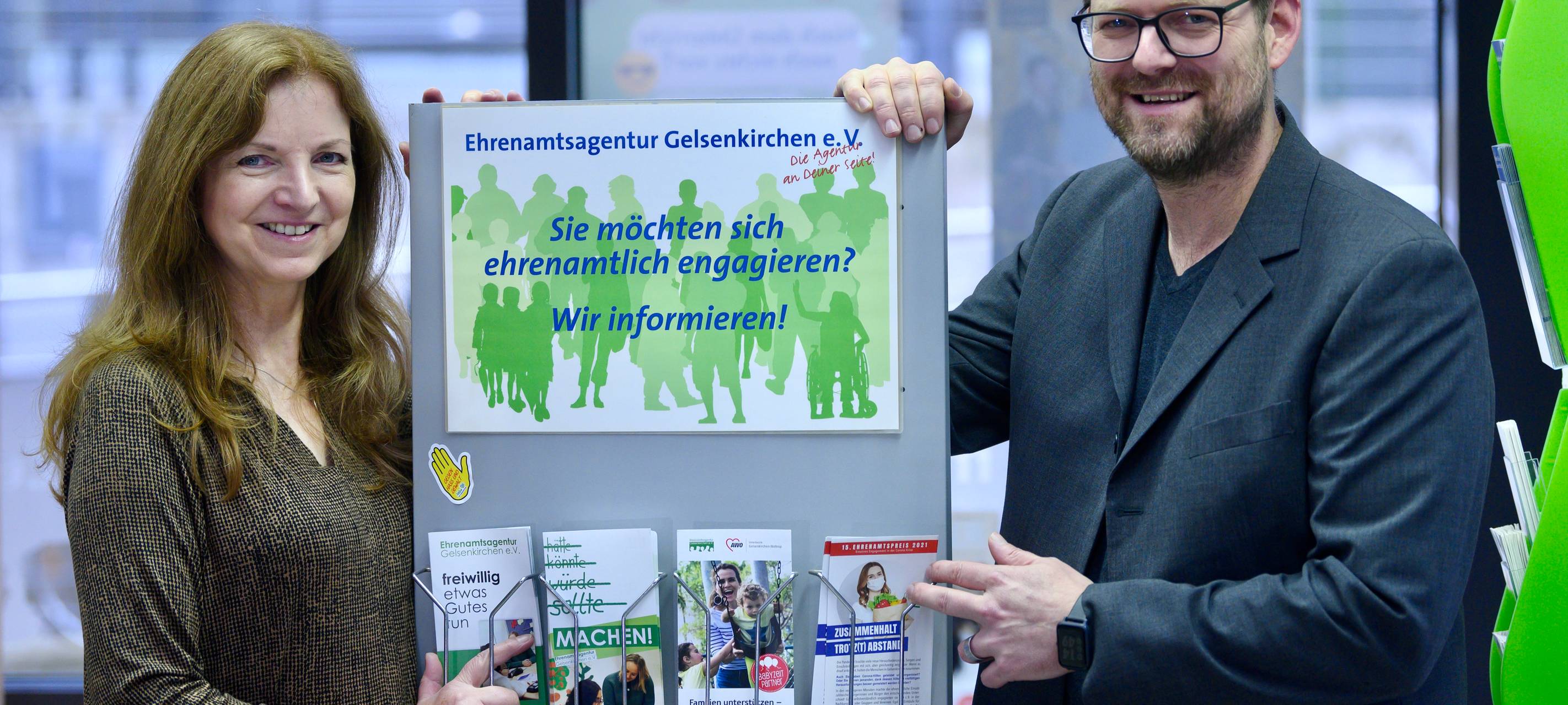 Mitarbeiter vor einem Schild der Ehrenamtsagentur Gelsenkirchen