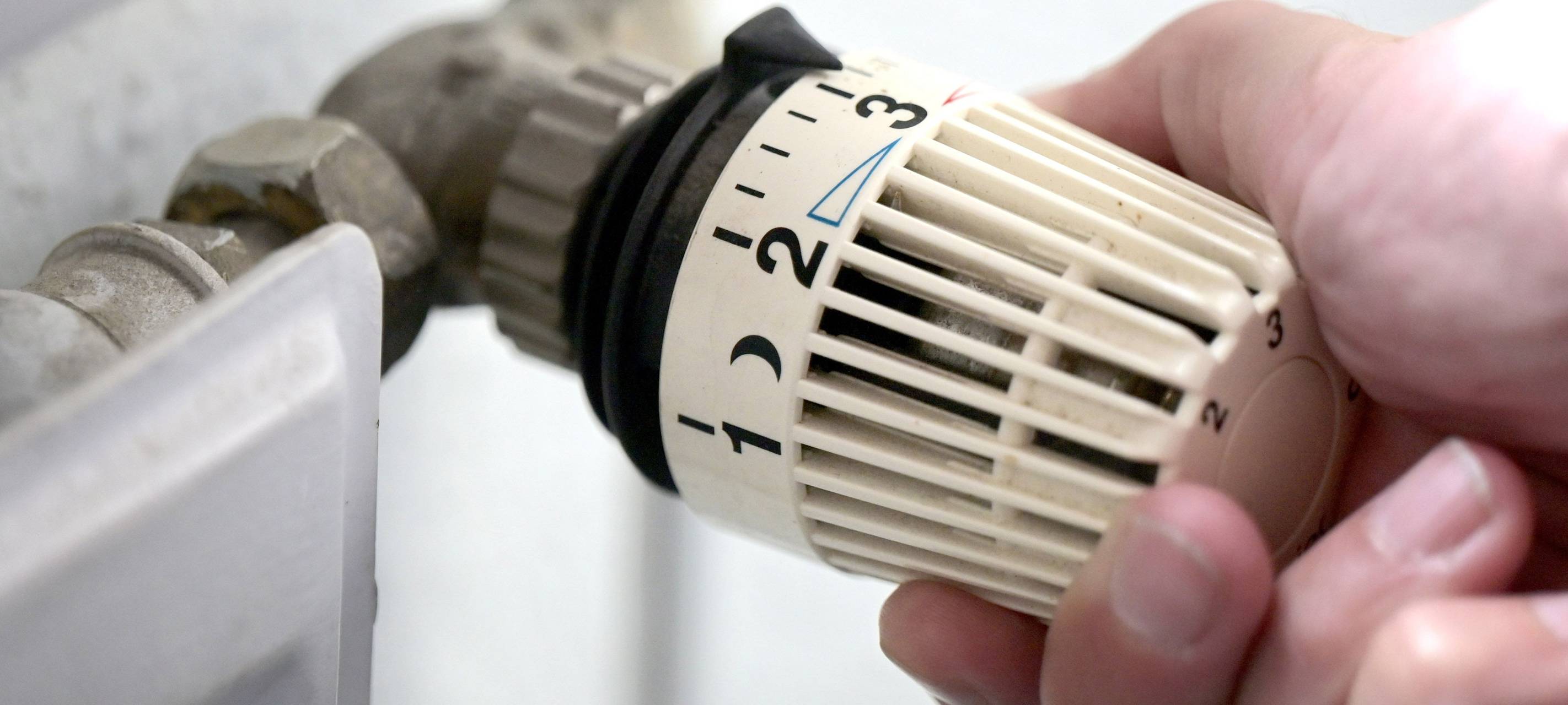 Ein Thermostat an der Heizung wird runter gedreht