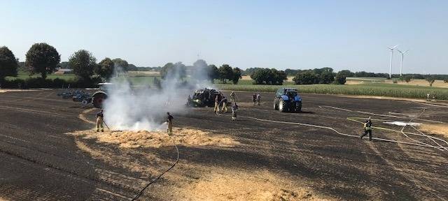 Löscharbeiten auf dem brennenden Getreidefeld