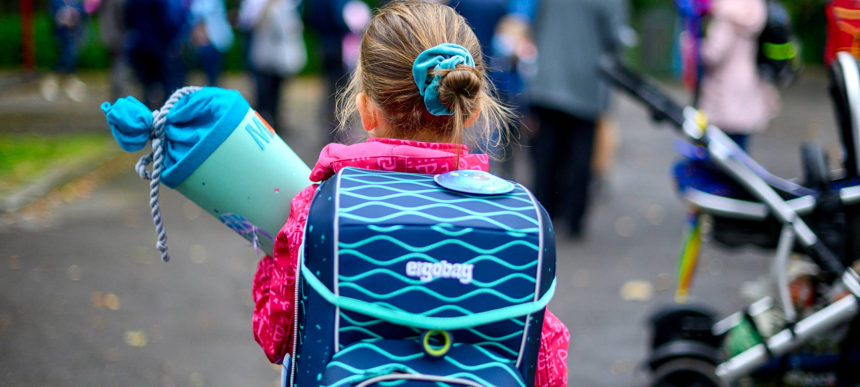 Eine Schulanfängerin mit Tornister und Schultüte