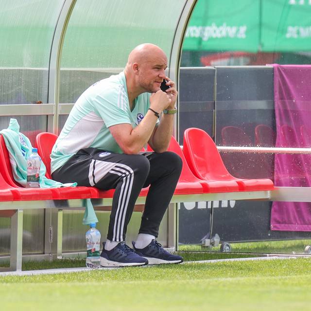 Schalke-Manager Rouven Schröder telefoniert am Rande des Trainingsplatzes