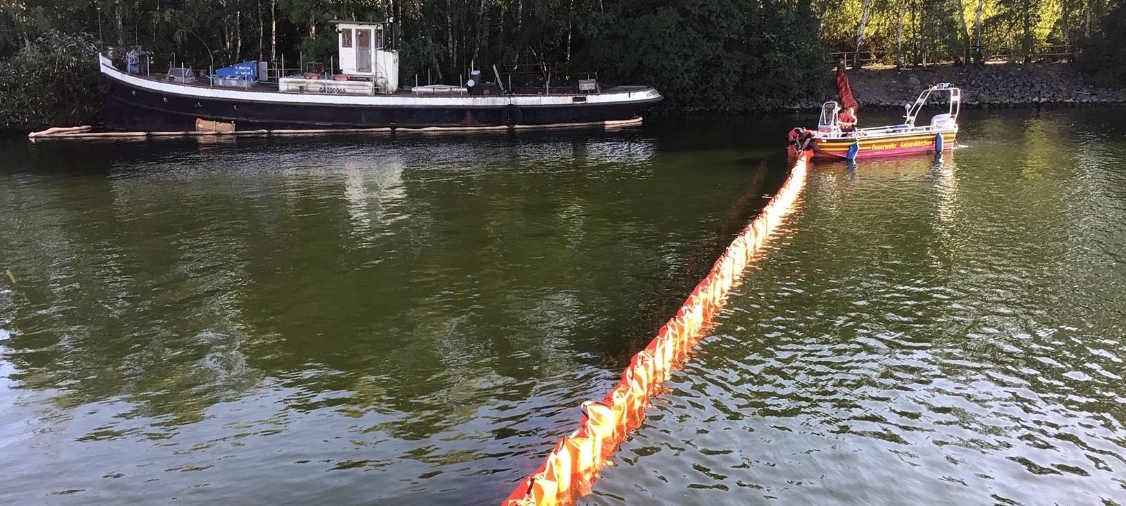 Ölsperre zwischen einem Schiff und dem Feuerwehrboot