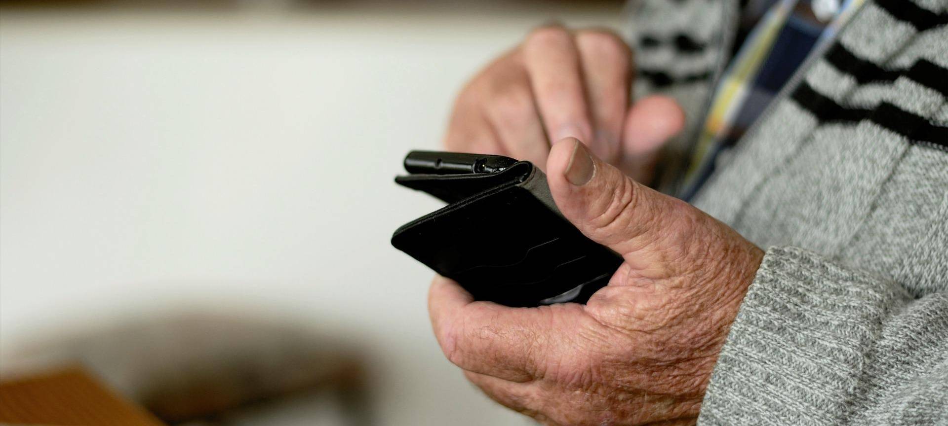 Ein älterer Mensch mit Handy