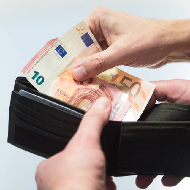 Ein Geldschein wird aus einem Portemonnaie gezogen