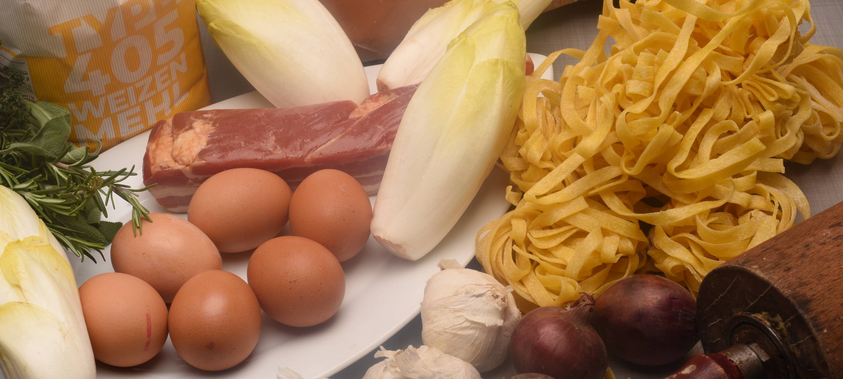 Pappardelle mit gebratenem Chicorée, getrockneten Tomaten und Speck