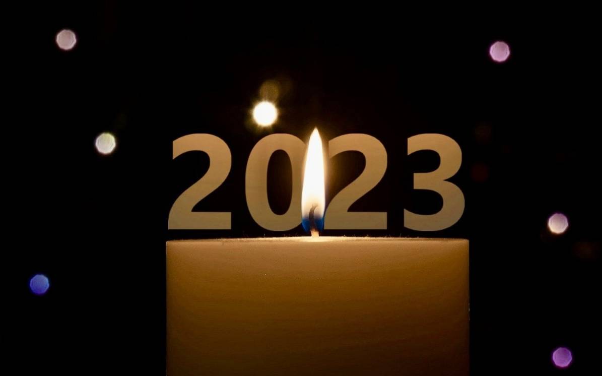 Eine Kerze mit Konfetti und der Zahl 2023