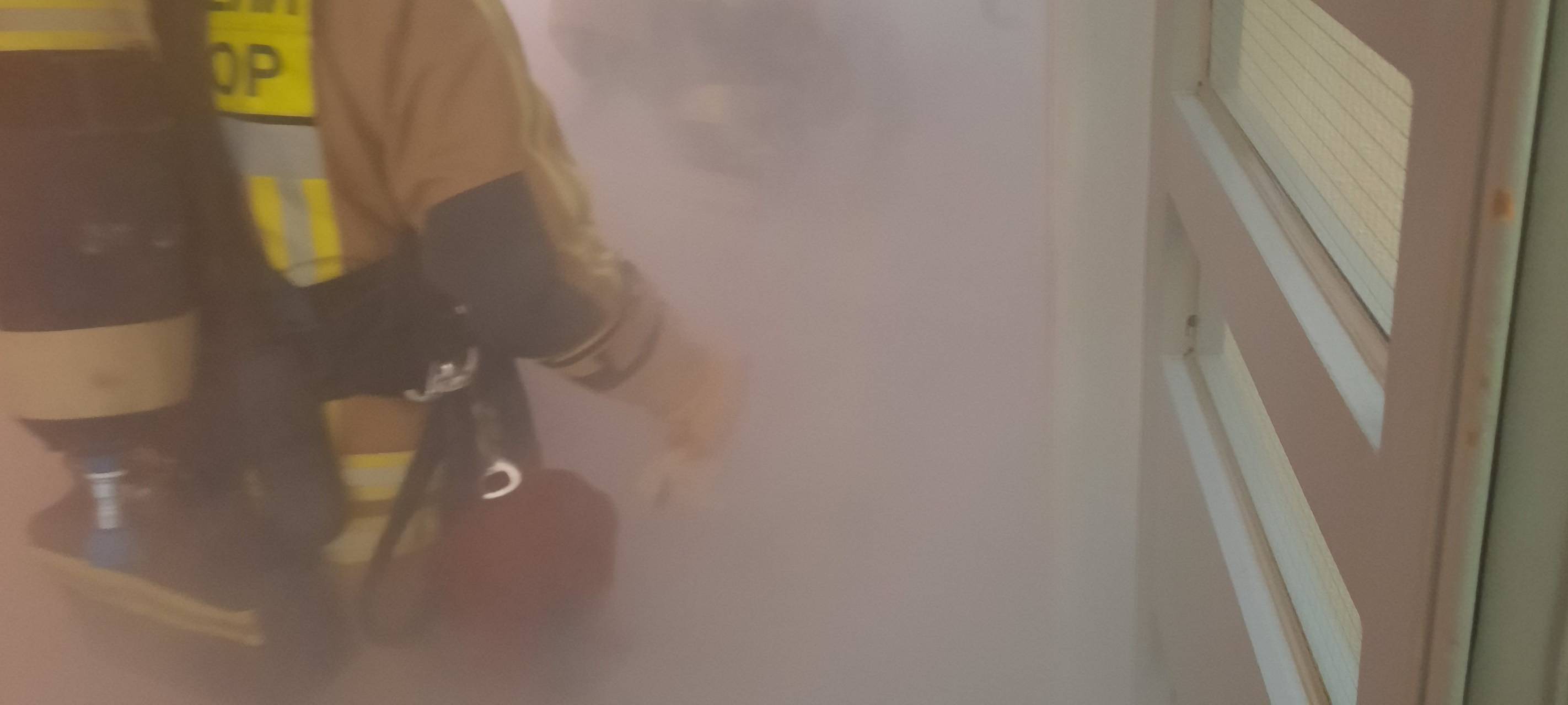 Feuerwehrmann unter Atemschutz in verrauchtem Treppenhaus