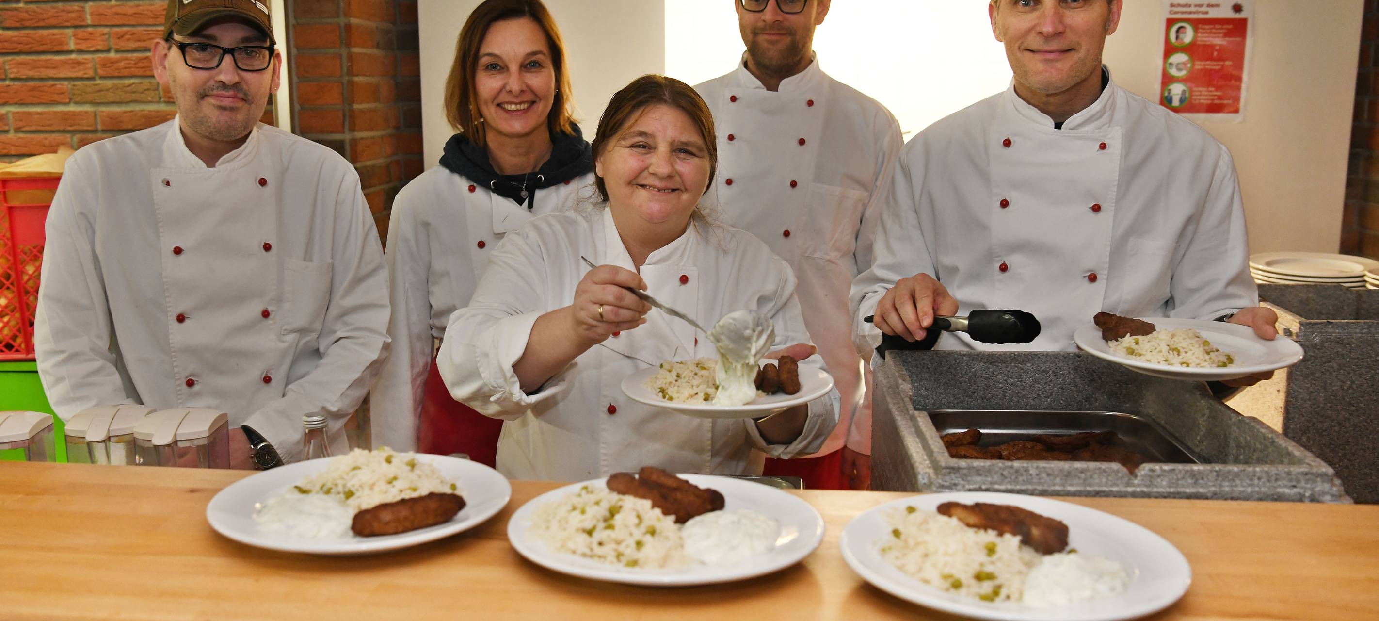 Köche füllen Teller in der Suppenküche Kolüsch (2023)